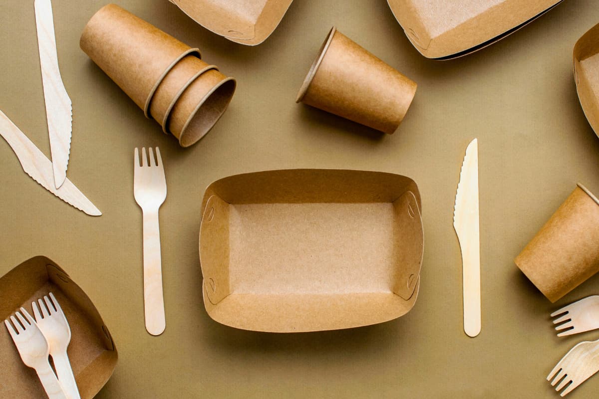 Empaques sostenibles para delivery hechos de cartón y madera, ideales para reducir el impacto ambiental en envíos de comida.