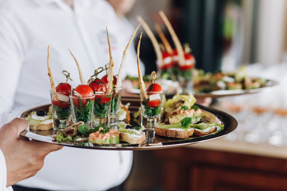 Bandeja con aperitivos gourmet servidos en evento; ejemplo visual ideal para marketing digital para servicio de catering.