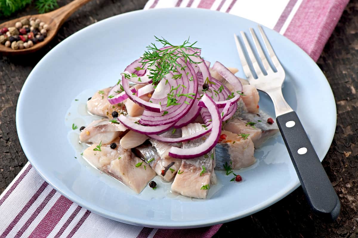 Ceviche con cebolla morada y eneldo, ideal para aprender cómo conservar ceviche para delivery sin perder su frescura.
