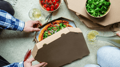 Esta imagen captura una escena relajada y cotidiana de una cena o reunión social, centrada en el disfrute de comida para llevar.