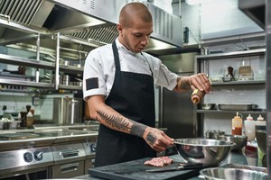 Chef prepara ingredientes en cocina profesional, representando de forma visual qué permisos necesito para abrir una dark kitchen.