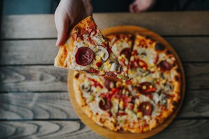 Pizza deliciosa, comida para vender que deje ganancia, con ingredientes variados como pepperoni, champiñones y maíz.