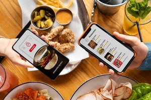 Personas usando apps en sus móviles mientras almuerzan, mostrando cómo hacer la gestión de pedidos de comida a domicilio.