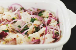 El ceviche está compuesto por trozos de pescado crudo marinados en jugo de limón, mezclados con cebolla morada, ají, y cilantro. Un símbolo icónico de la rica gastronomía peruana.