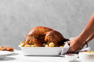 Pollo asado servido con papas, listo para disfrutar como parte de un menú especial para el Día del Pollo a la Brasa.