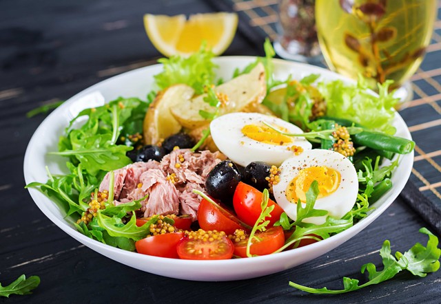 Comida rentable: prato de salada com ovos cozidos, tomate-cereja, atum e alface