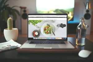 Computadora mostrando la foto de un plato en un blog, representando los tipos de publicidad de restaurantes.