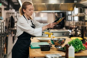 Chef preparando alimentos en una cocina industrial, ejemplificando el concepto de qué es dark kitchen en la cocina moderna.